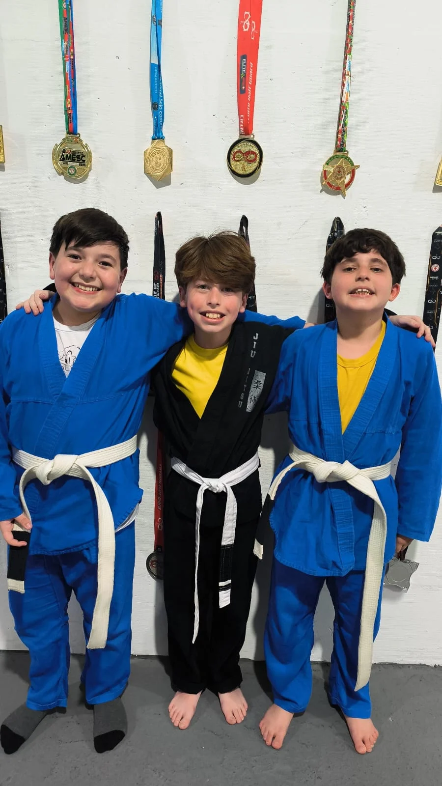 Três alunos da turma infantil da Vanguard juntos no tatame
